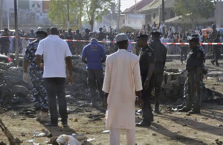 Bomb squad experts and security personnel inspecting bike wreckages at a scene of multiple bombings at the Kano Central Mosque November 28, 2014. REUTERS/Stringer