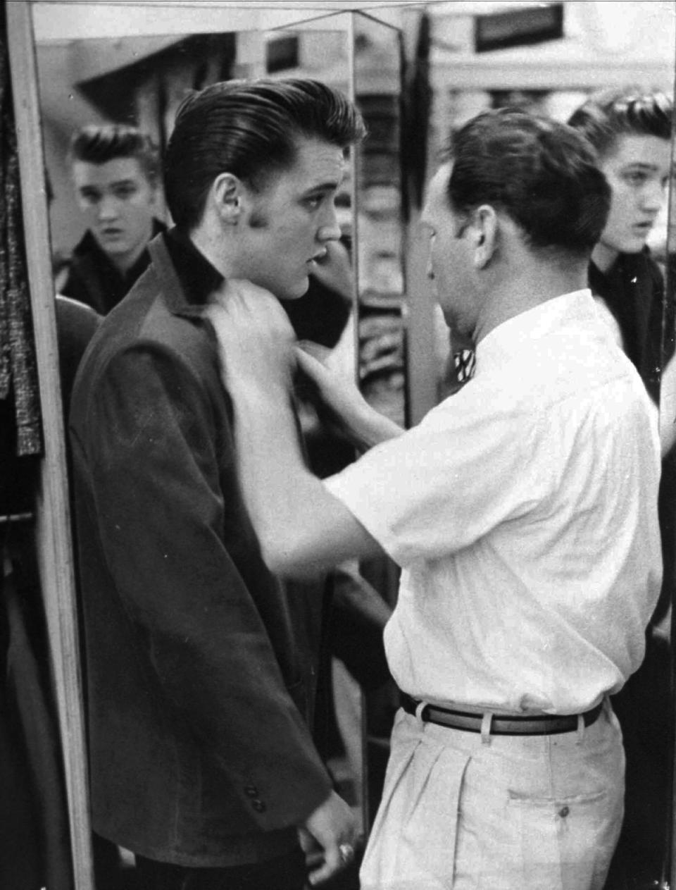 FILE - This 1956 file photo originally released courtesy of Bernard Lansky shows singer Elvis Presley, left, being outfitted by clothier Bernard Lansky at Lansky's Men's Store in Memphis, Tenn. Lansky, who helped a young Elvis Presley establish his signature clothing style, died Thursday, Nov. 15, 2012 at his Memphis home, according to his granddaughter Julie Lansky. He started his retail business in Memphis in 1946 with a $125 loan from his father, Samuel. He was 85. (AP Photo/courtesy of Bernard Lansky, File)