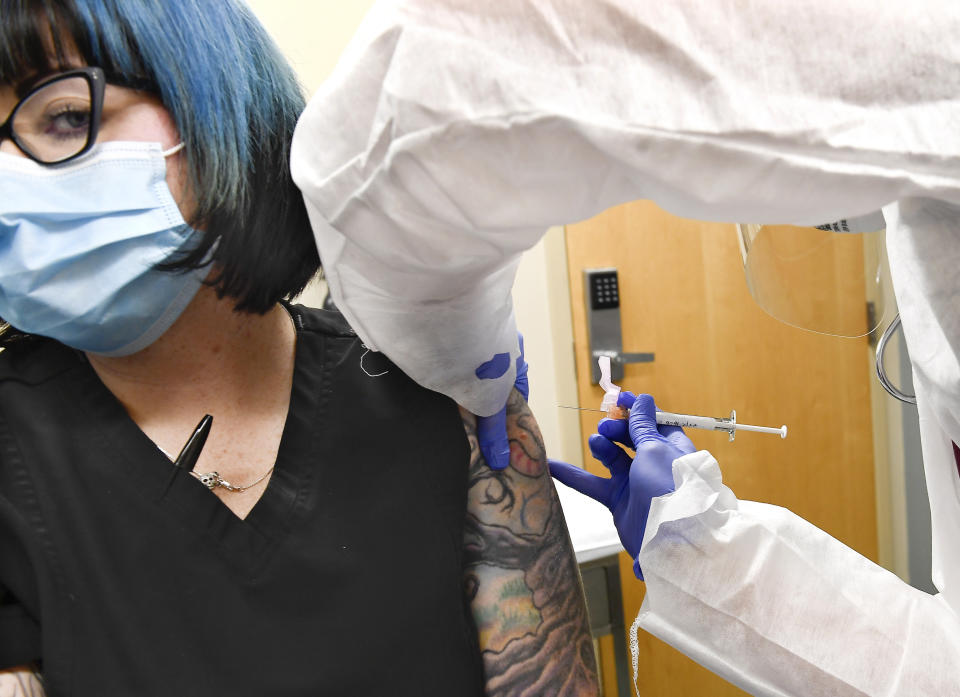 Nurse Kathe Olmstead, right, gives volunteer Melissa Harting, of Harpursville, N.Y., an injection as the world's biggest study of a possible COVID-19 vaccine, developed by the National Institutes of Health and Moderna Inc., gets underway Monday, July 27, 2020, in Binghamton, N.Y. (AP Photo/Hans Pennink)