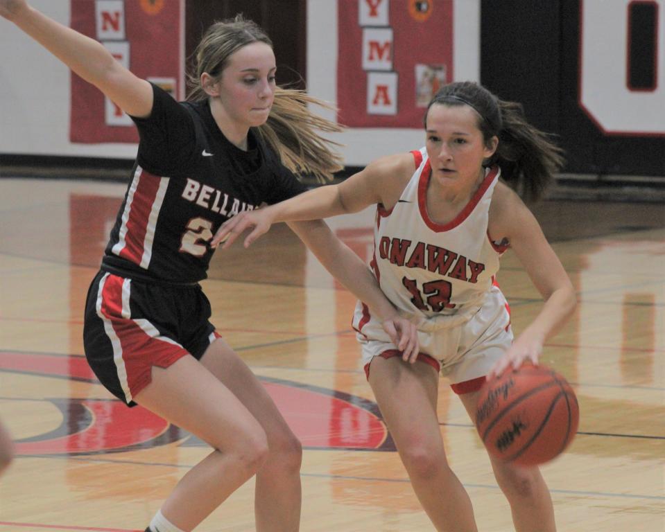 Onaway sophomore guard Marley Szymoniak (right) drives past a Bellaire player during the first half of a girls basketball clash at Onaway on Friday.
