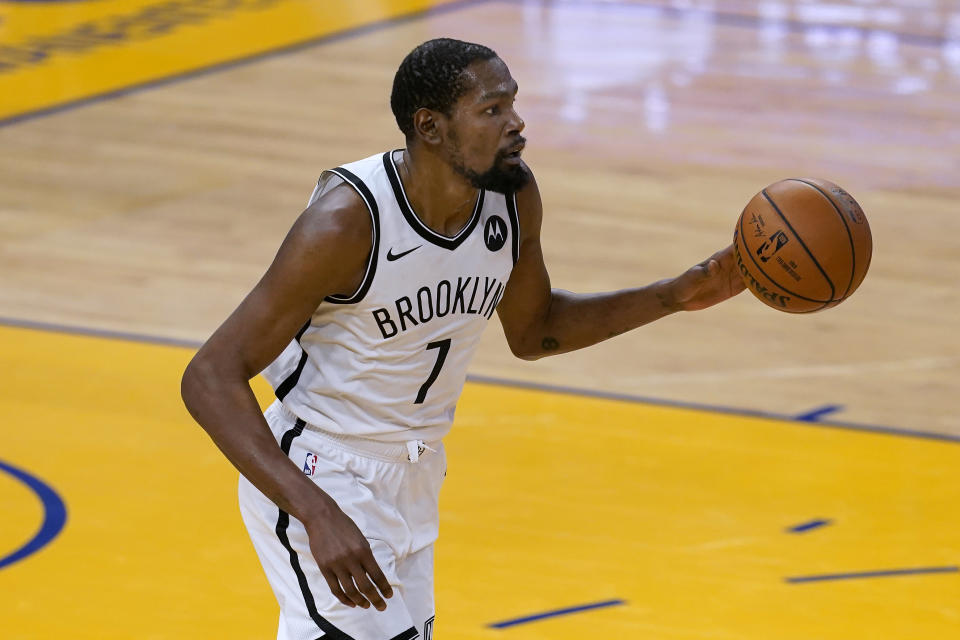 Brooklyn Nets forward Kevin Durant brings the ball up against the Golden State Warriors during the first half of an NBA basketball game in San Francisco, Saturday, Feb. 13, 2021. (AP Photo/Jeff Chiu)