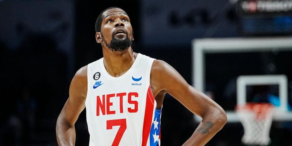 Kevin Durant stands with his hands on his hips and looks up during a Nets game.