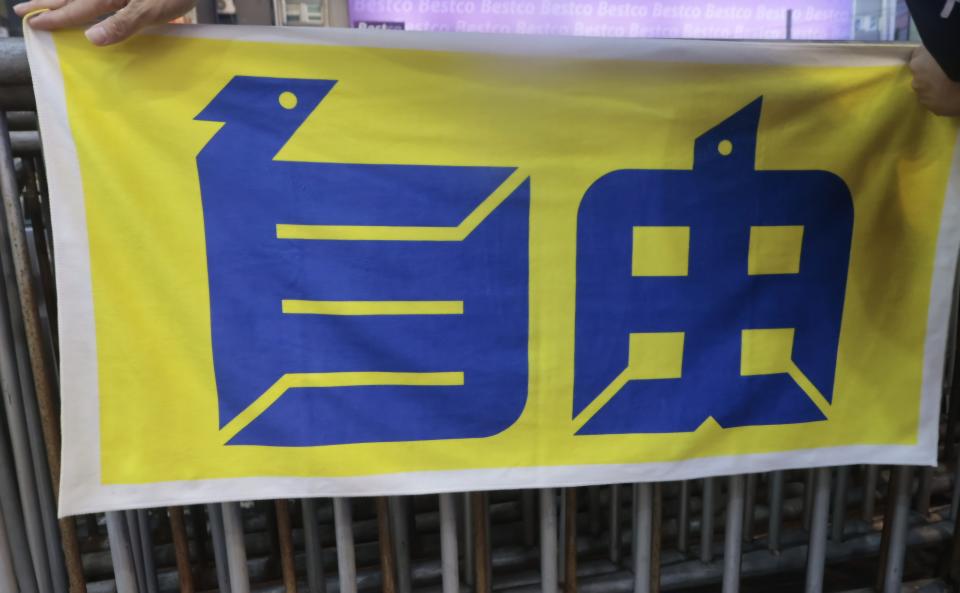 ET帶著一條寫有「自由」字樣的毛巾，反面是「風雨」。