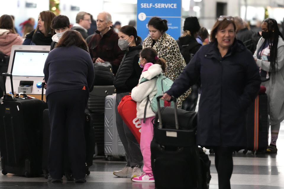 Travelers check their tickets at the O'Hare International Airport in Chicago, Thursday, Dec. 21, 2023. It's beginning to look a lot like a hectic holiday travel season, but it might go relatively smoothly if the weather cooperates. (AP Photo/Nam Y. Huh)