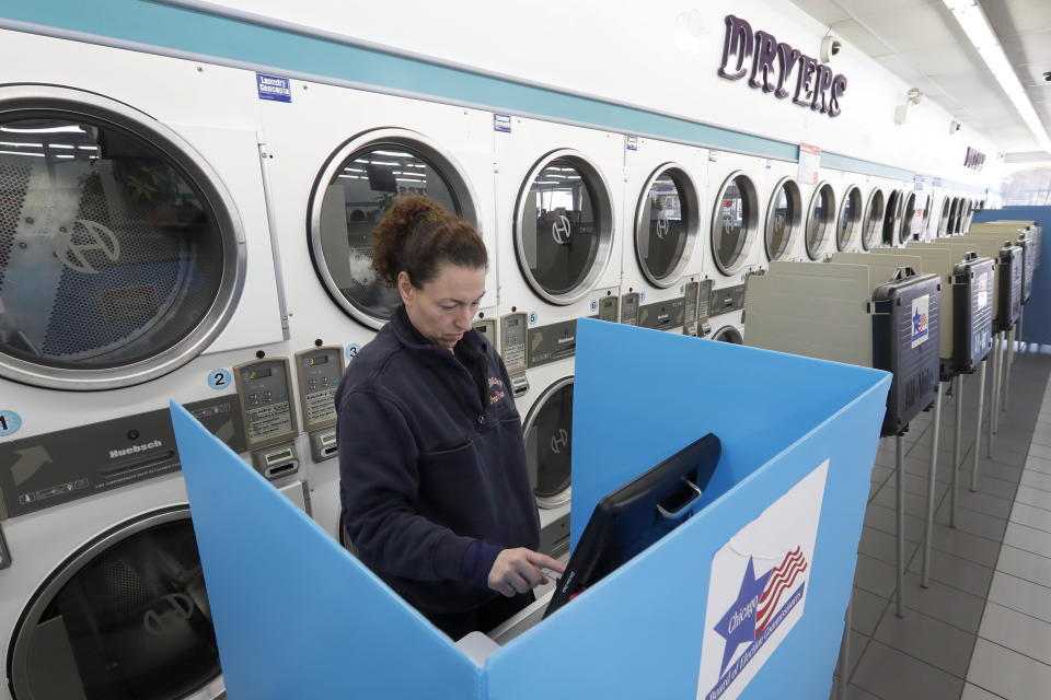 Lisette Venegas votes at Chicago's Su Nueva Lavanderia polling place on March 17, 2020. Election officials have been promoting voting early and casting ballots by mail in an attempt to limit crowds and curb the spread of the coronavirus. (Photo: ASSOCIATED PRESS)