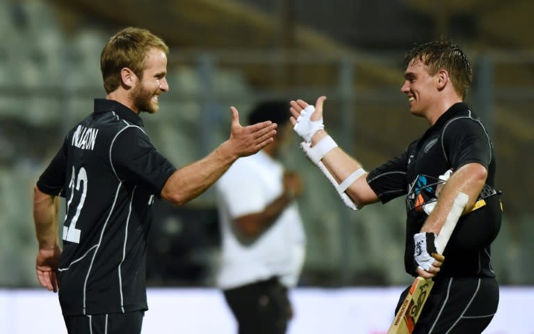 New Zealand captain Kane Williamson (L) greets teammate Tom Latham after winning the first one-day international cricket match against India at the Wankhede stadium in Mumbai on October 22, 2017