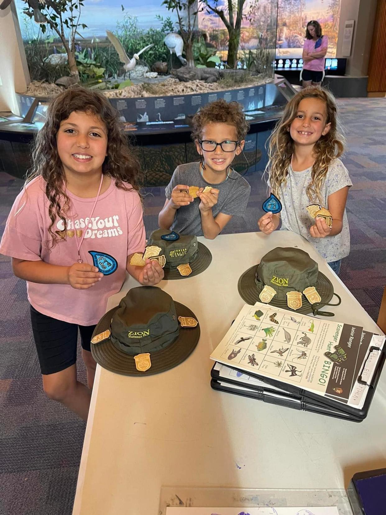 Daniella, Jonathan and Maya  Zrihen proudly show off the Junior Ranger badges they've earned.
