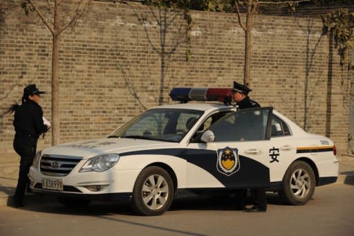 A police car is seen outside the studio of Chinese artist Ai Weiwei in Beijing on November 14, 2011. Ai -- who has been banned from leaving Beijing since his release -- denies the government's charge that he evaded taxes for years, insisting it is a politically motivated attempt to silence his vocal rights activism