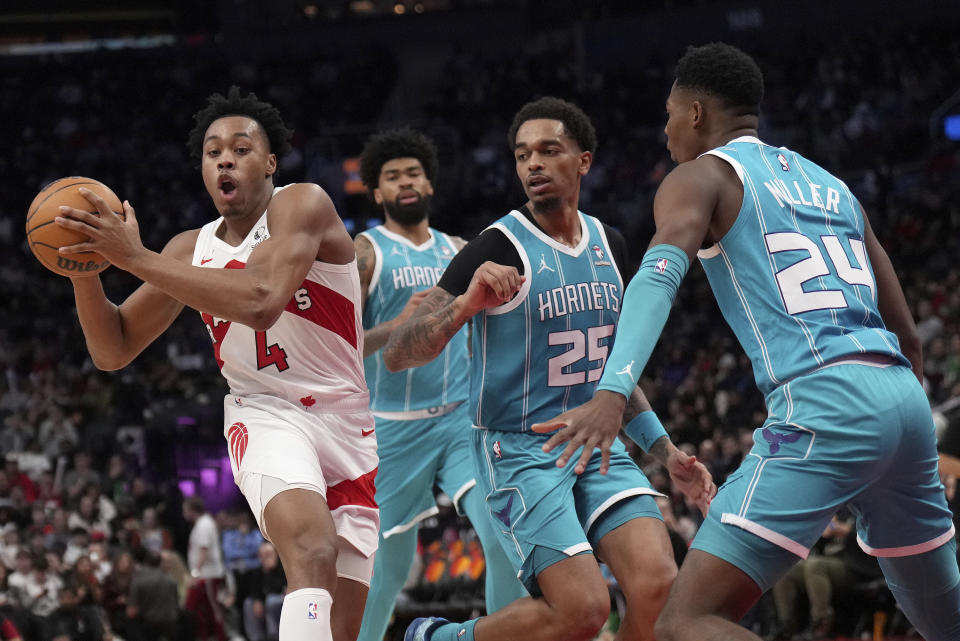 Toronto Raptors forward Scottie Barnes (4) looks for the pass as Charlotte Hornets forward P.J. Washington (25) and teammate Brandon Miller (24) look on during the second half of an NBA basketball game in Toronto, Monday, Dec. 18, 2023. (Nathan Denette/The Canadian Press via AP)
