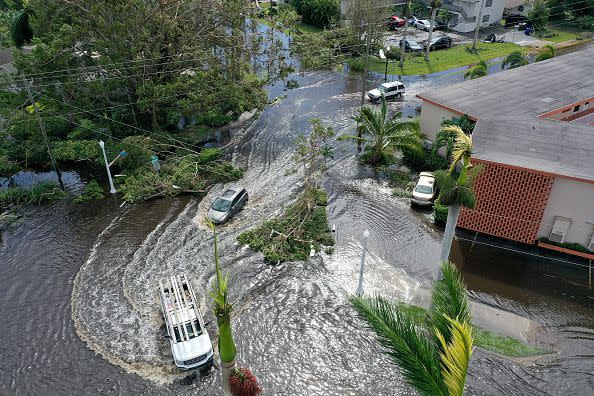 FORT MYERS FLORIDA - SEPTEMBER 29:  In this aerial view, vehicles make their way through a flooded area after Hurricane Ian passed through on September 29, 2022 in Fort Myers, Florida. The hurricane brought high winds, storm surge and rain to the area causing severe damage. (Photo by Joe Raedle/Getty Images)