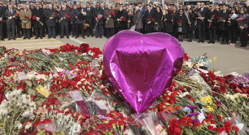 A group of ambassadors of foreign diplomatic missions attend a laying ceremony at a makeshift memorial in front of the Crocus City Hall on the western outskirts of Moscow, Russia, Saturday, March 30, 2024. (Sergei Ilnitsky/Pool Photo via AP)