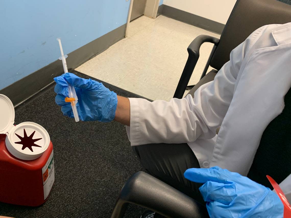 A pharmacist at a Miami-Dade County Walgreens prepares to give a patient an injection of the newly updated COVID-19 booster that is designed to target the original COVID strain, as well as omicron BA.4 and BA.5, on Sept. 7, 2022.