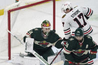 Chicago Blackhawks' Dylan Strome, right, looks for the rebound of the puck off Minnesota Wild goalie Kaapo Kahkonen, left, during the first period of an NHL hockey game Saturday, Jan. 22, 2022, in St. Paul, Minn. (AP Photo/Jim Mone)