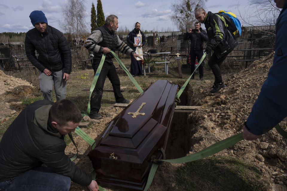 Relatives and friends attend the funeral of Andriy Matviychuk, 37, who served as territorial defense soldier, was captured by Russian army, tortured and killed in Bucha, in the outskirts of Kyiv, Ukraine, Tuesday, April 12, 2022. (AP Photo/Rodrigo Abd)