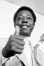 FILE - Atlanta Braves' Hank Aaron gives the thumbs-up sign to reporters indicating he will play in the season opener against the Cincinnati Reds at Riverfront Stadium in Cincinnati, in this April 4, 1974, file photo. Hank Aaron, who endured racist threats with stoic dignity during his pursuit of Babe Ruth’s home run record and gracefully left his mark as one of baseball’s greatest all-around players, died Friday. He was 86. The Atlanta Braves, Aaron's longtime team, said he died peacefully in his sleep. No cause was given.(AP Photo/File)