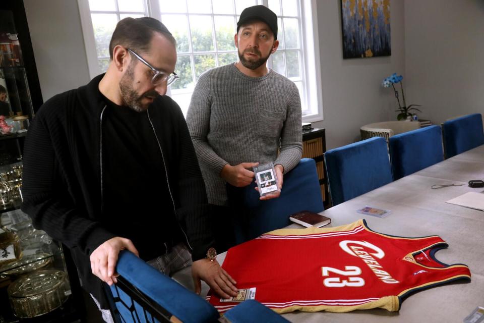 Steven Spiegel, left, examines a LeBron James Cleveland Cavaliers jersey