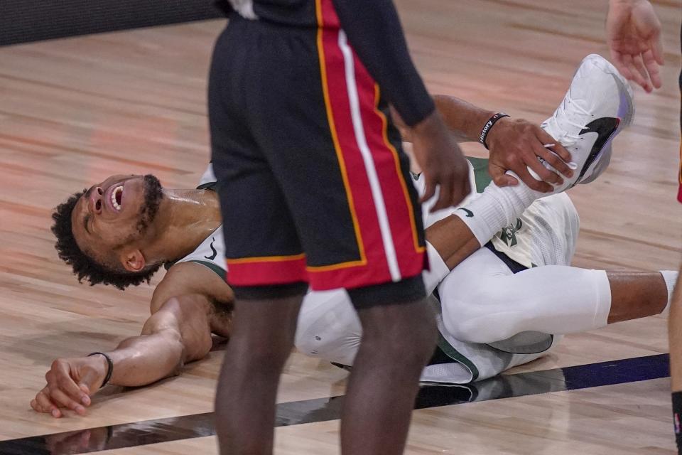 Milwaukee Bucks' Giannis Antetokounmpo reacts after hurting his ankle during the first half of an NBA conference semifinal playoff basketball game against the Miami Heat Sunday, Sept. 6, 2020, in Lake Buena Vista, Fla. (AP Photo/Mark J. Terrill)