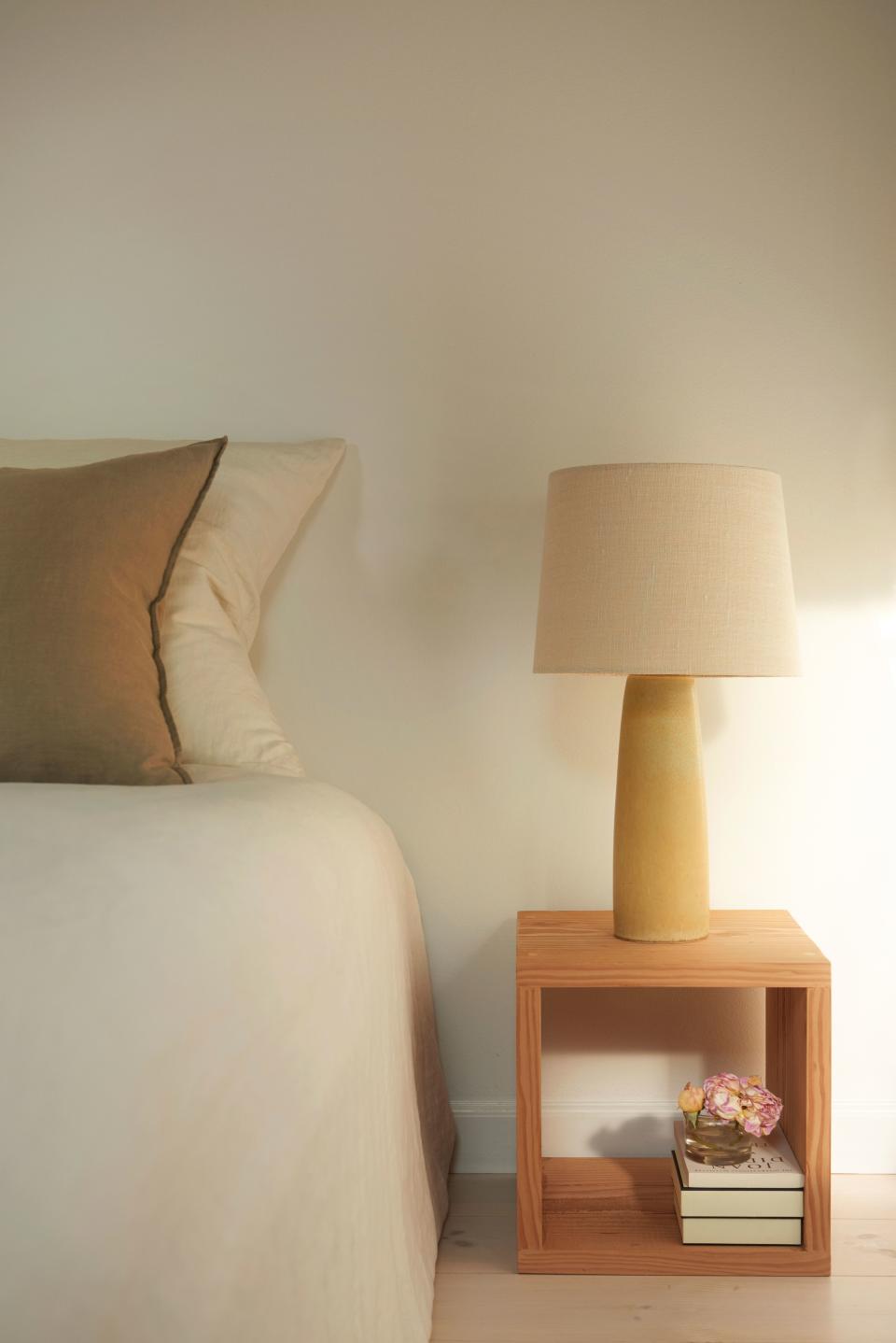 An antique Danish lamp by the ceramist Palshus (with a new linen shade—perhaps the easiest way to update an antique lighting fixture) sits atop a more modern bedside table made by Steffan. Everything in the room is intentional, useful, and uncluttered: In the bedside table sits a small box with a silk eye mask and essential oils, the book Feiffer is currently reading, and a garden flower.