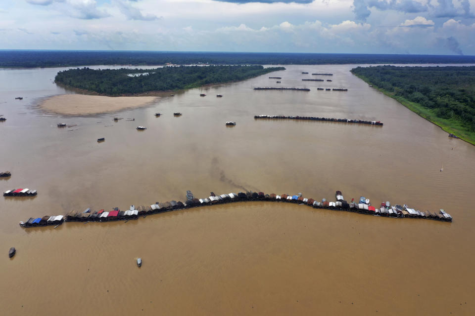 Dredging barges operated by illegal miners converge on the Madeira river, a tributary of the Amazon river, searching for gold, in Autazes, Amazonas state, Brazil, Thursday, Nov.25, 2021. Hundreds of mining barges have arrived during the past two weeks after rumors of gold spread, with environmentalists sounding the alarm about the unprecedented convergence of boats in the sensitive ecosystem. (AP Photo/Edmar Barros)