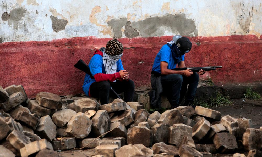 Pro-government supporters sit in a barricade after clashes with demonstrators in Monimbó, Masaya