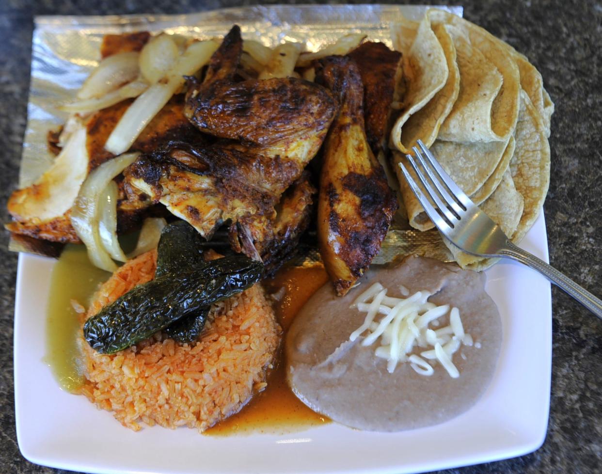 A half grilled chicken dinner with rice, beans, fried jalapeño toreados and tortillas is served at Don Juan Authentic Mexican Grill in Newburgh on Sunday, April 21, 2024.