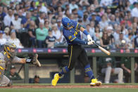 Seattle Mariners' Dylan Moore, right, hits a home run as Oakland Athletics catcher Shea Langeliers, left, looks on during the fourth inning of a baseball game, Friday, May 10, 2024, in Seattle. (AP Photo/Jason Redmond)