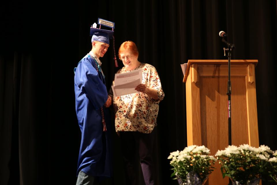 Gannon Meis receives the Knights of Columbus and St. Patrick's Regina Guild Scholarships from Peggy Fagen during the Senior Awards Assembly on Wednesday, May 17, 2023, at Perry Performing Arts Center.