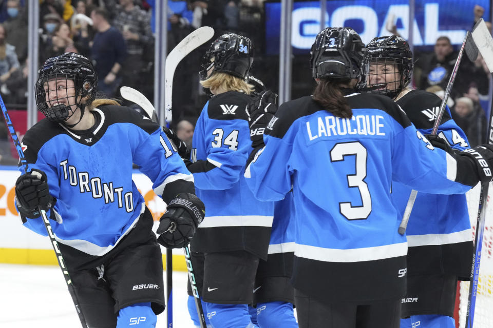 Toronto's Jesse Compher, left, celebrates with teammates after scoring against Montreal during third-period PWHL hockey game action in Toronto, Friday, Feb. 16, 2024. (Chris Young/The Canadian Press via AP)