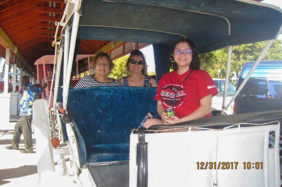 Amedy Dewey, in red, poses for a photo with her grandmother Pat Foster, left, and her mother, Lisa Somers, center, during a horse carriage ride to see the sights in Nassau, Bahamas, on Dec. 31, 2017.