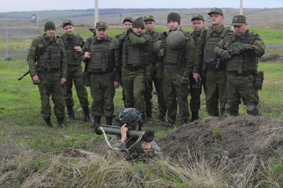 FILE - Recruits listen to an instructor showing how to use a man-portable missile during a military training at a firing range in the Rostov-on-Don region in southern Russia, Oct. 4, 2022. Since Russian President Vladimir Putin announced his mobilization on Sept. 21 for the war in Ukraine, independent media, human rights activists and draftees themselves have painted a bleak picture of a haphazard, chaotic and ethnically biased effort to round up as many men as possible and push them quickly to the front, regardless of skill or training. (AP Photo/File)