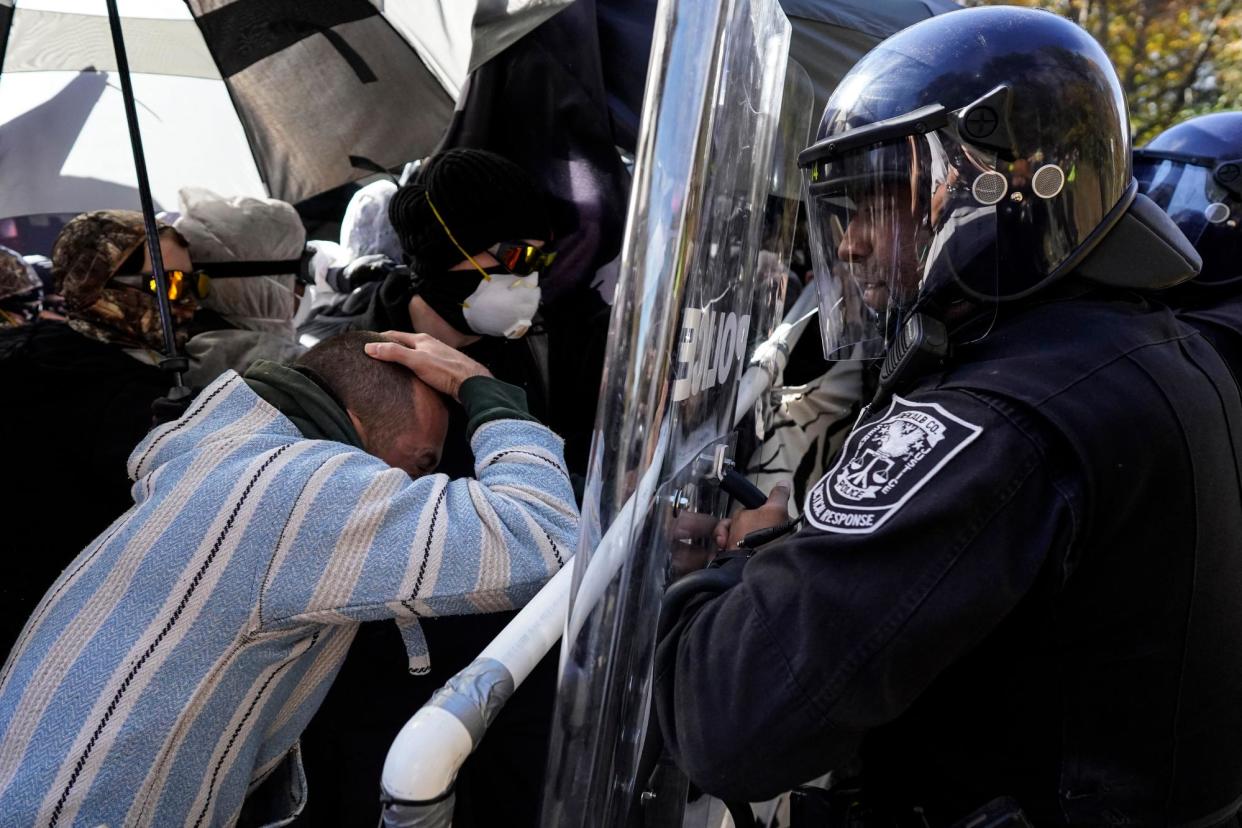 <span>Protesters and police during a demonstration in opposition to the ‘Cop City’ training center on 13 November 2023 in Atlanta, Georgia.</span><span>Photograph: Mike Stewart/AP</span>