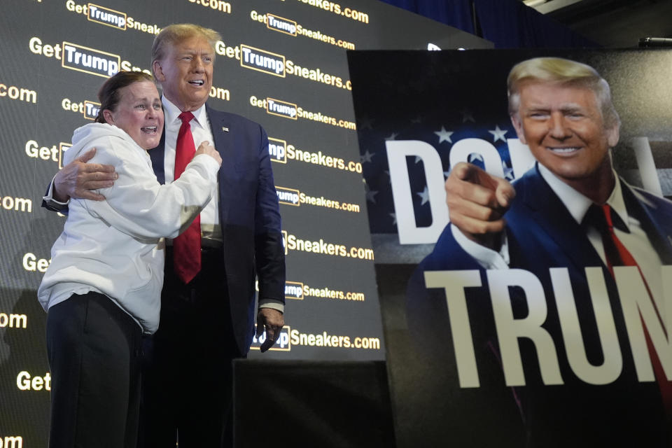 Republican presidential candidate former President Donald Trump hugs supporter Donna Bernhard of Adamstown, Pa., as he attends Sneaker Con Philadelphia, an event popular among sneaker collectors, and announces a gold Trump sneaker, in Philadelphia, Saturday, Feb. 17, 2024. (AP Photo/Manuel Balce Ceneta)