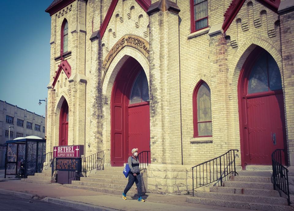 A woman walks by a church along North Avenue in Milwaukee.