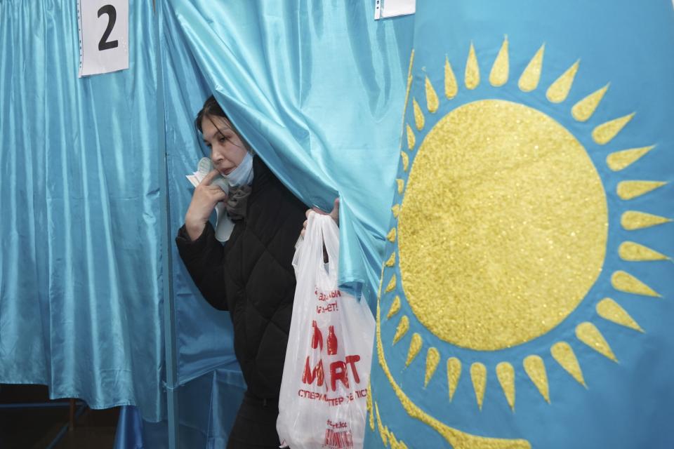 A woman leaves a voting booth to cast his ballot at a polling station in Almaty, Kazakhstan, Sunday, March 19, 2023. Voters in Kazakhstan cast ballots on Sunday after a short but active campaign for seats in the lower house of parliament that is being reconfigured in the wake of deadly unrest that gripped the resource-rich Central Asian nation a year ago. (Vladimir Tretyakov/NUR.KZ via AP)