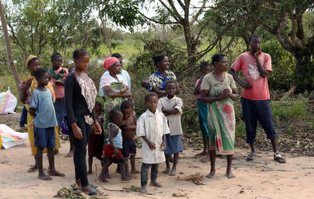 People wait to collect food parcels handed out by an aid organisation to locals after Cyclone Idai, near Dondo village outside Beira, Mozambique, March 24, 2019. REUTERS/Siphiwe Sibeko