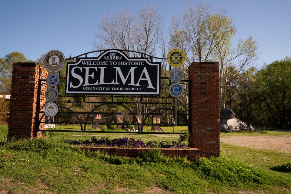 A sign welcoming visitors to Selma, Alabama sits in the Civil Rights Memorial Park near the foot of the Edmund Pettus Bridge.