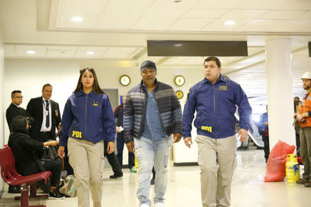 American boxer Mike Tyson (C) is escorted by members of the Investigative Police of Chile (PDI) at the Santiago International Airport in Santiago, Chile November 9, 2017. Courtesy of Policia de Investigaciones de Chile/Handout via REUTERS ATTENTION EDITORS - THIS IMAGE WAS PROVIDED BY A THIRD PARTY.