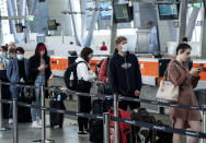 Passengers queue to check in for flights to Queensland at Sydney Domestic Airport, Sydney, Friday, July 31, 2020. Tourism operators across Asia and the Pacific are making furtive and faltering advances, as well as some spectacular missteps, after travel was largely halted by the coronavirus pandemic that continues ebbing and mostly surging around the globe. Struggling tourism businesses in Queensland, known as Australia’s Sunshine State, will soon lose visitors from the nation’s biggest city, Sydney. A growing Sydney outbreak led the Queensland government to reconsider and Sydney visitors will now be banned from Saturday.(James Gourley/AAP Image via AP)