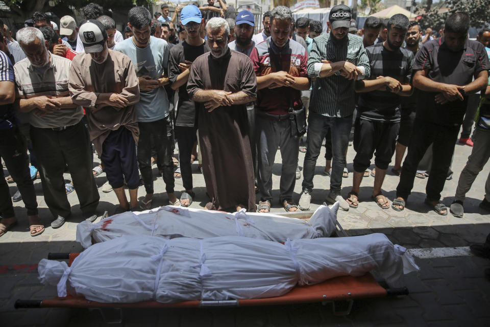 Mourners pray for two Palestinians during their funeral at Al-Aqsa Martyrs Hospital in Deir al Balah, Gaza Strip, Friday, June 14, 2024. An Israeli airstrike on a home in the central city in the Gaza Strip killed two people and wounded several others including children, hospital officials said. (AP Photo/Mohammad Hajjar)