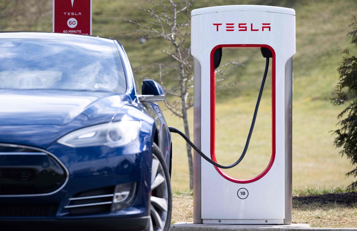 A Tesla Model S sedan is plugged into a Tesla Supercharger electrical vehicle charging station in Falls Church, Virginia on Feb. 13, 2023.