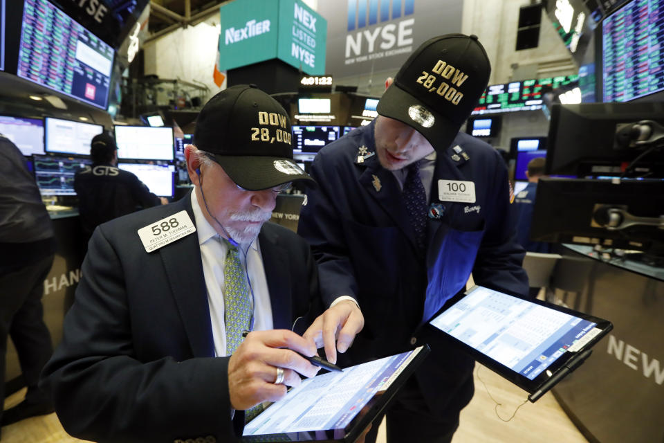 Traders Peter Tuchman, left, and his son Benjamin Tuchman, wear &quot;Dow 28,000&quot; hats at the close of trading on the floor of the New York Stock Exchange, Friday, Nov. 15, 2019. The Dow Jones Industrial Average added 222 points, or 0.8%, to 28,004. (AP Photo/Richard Drew)