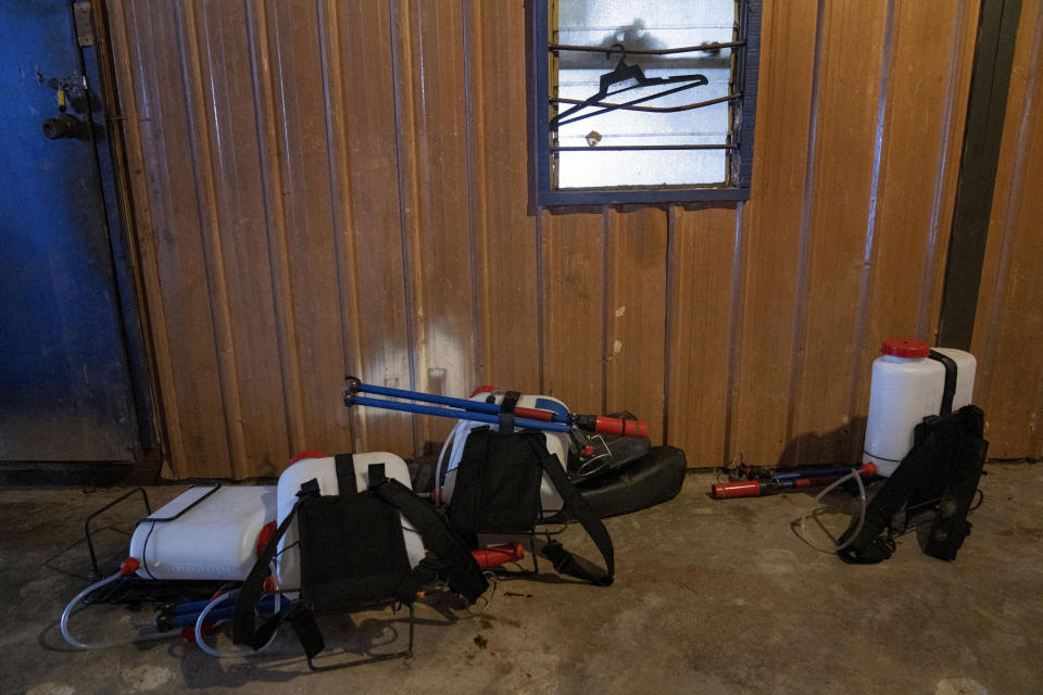 Spraying equipment lies in a worker's living quarters made of shipping containers in a palm oil plantation run by government-owned Felda in Malaysia, in early 2020. Jum, a former worker who escaped from this same plantation, described to The Associated Press how the company confiscated, described sleeping on the ground, exposed to the wind and monsoon rains, with only a campfire to fend off snakes and tigers. (AP Photo/Ore Huiying)