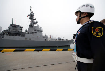 A Chinese navy personnel stands guard as the Japan Maritime Self-Defense Force destroyer JS Suzutsuki (DD 117) arrives at Qingdao Port for the 70th anniversary celebrations of the founding of the Chinese People's Liberation Army Navy (PLAN), in Qingdao, China April 21, 2019. REUTERS/Jason Lee