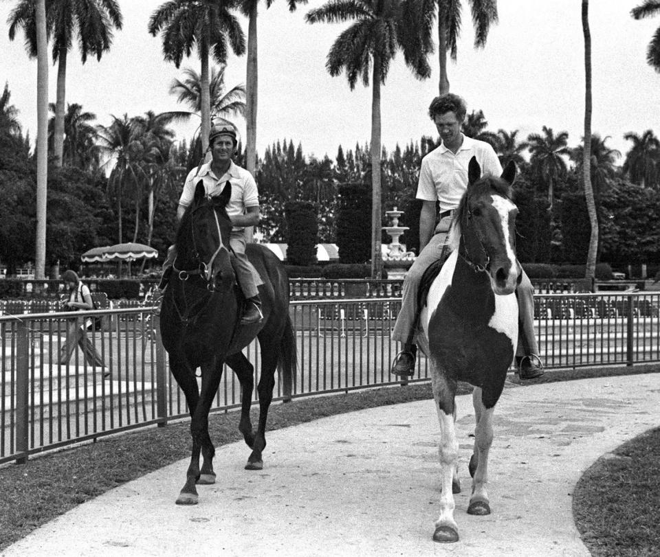 Exercise rider Mike Kennedy (left) rides 1977 Triple Crown winner Seattle Slew, and trainer Billy Turner (right) rides the paint pony Steamboat.