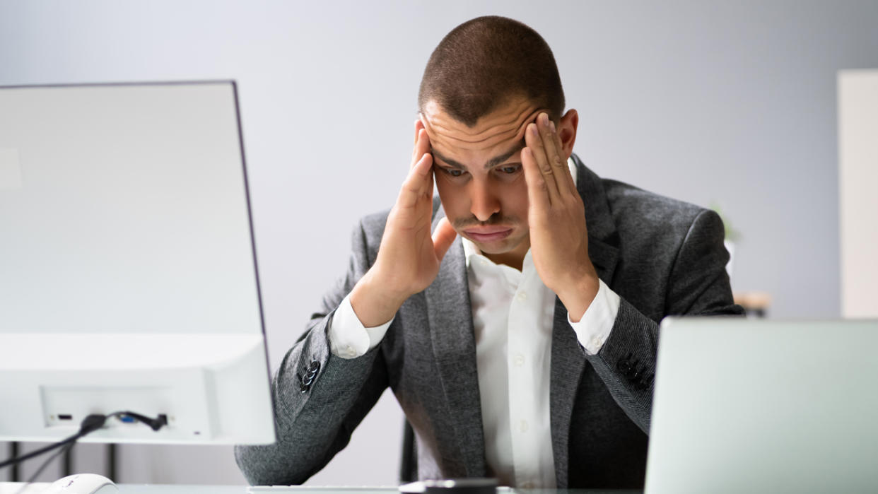 Upset worried man using laptop In office. (Getty Images)