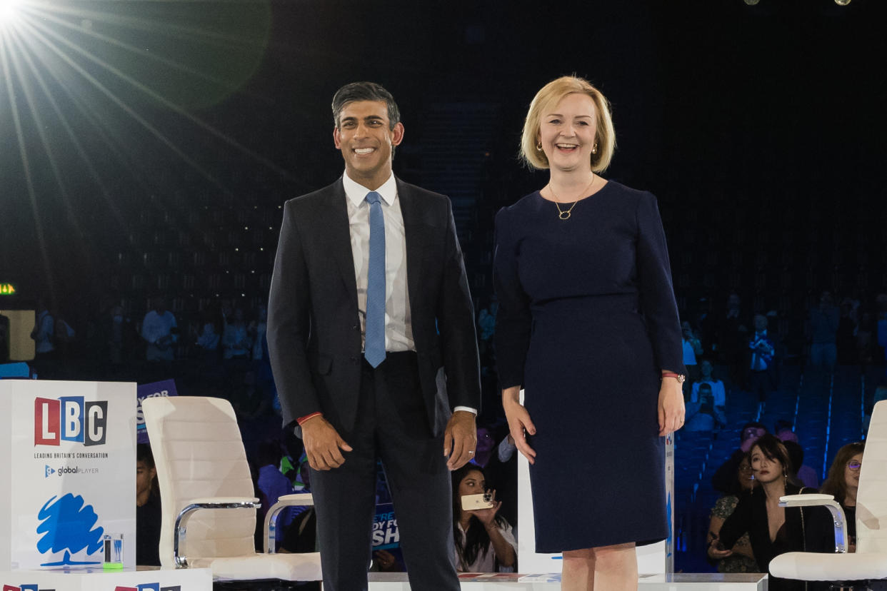 Rishi Sunak and Liz Truss stand to applause on a BBC television soundstage.