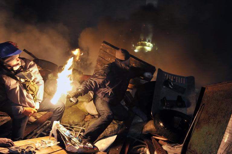 A protester hurls a molotov cocktail towards police from the barricades at Independence square in Kiev on February 19, 2014