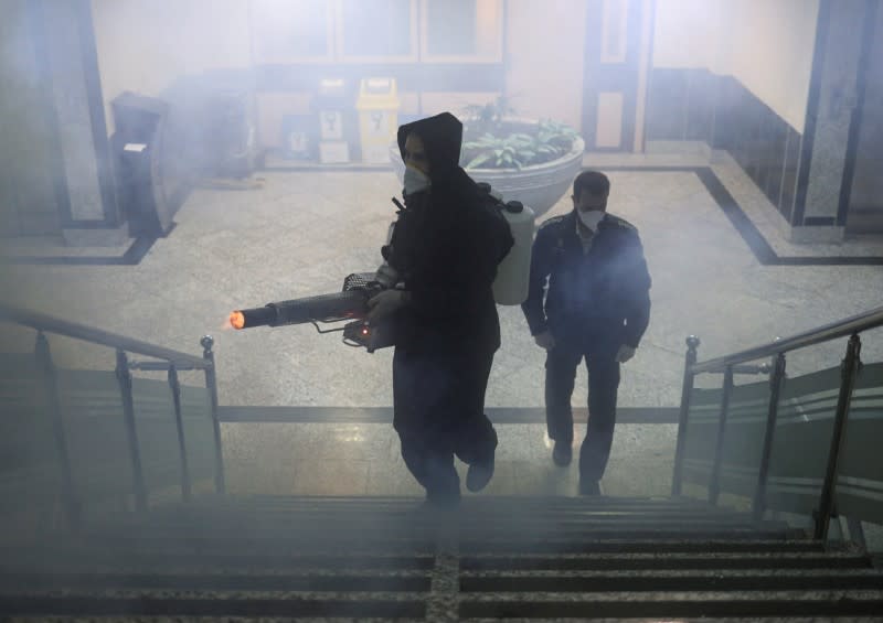 Members of firefighters wear protective face masks, amid fear of coronavirus disease (COVID-19), as they disinfect a municipality building, ahead of the Iranian New Year Nowruz, March 20, in Tehran