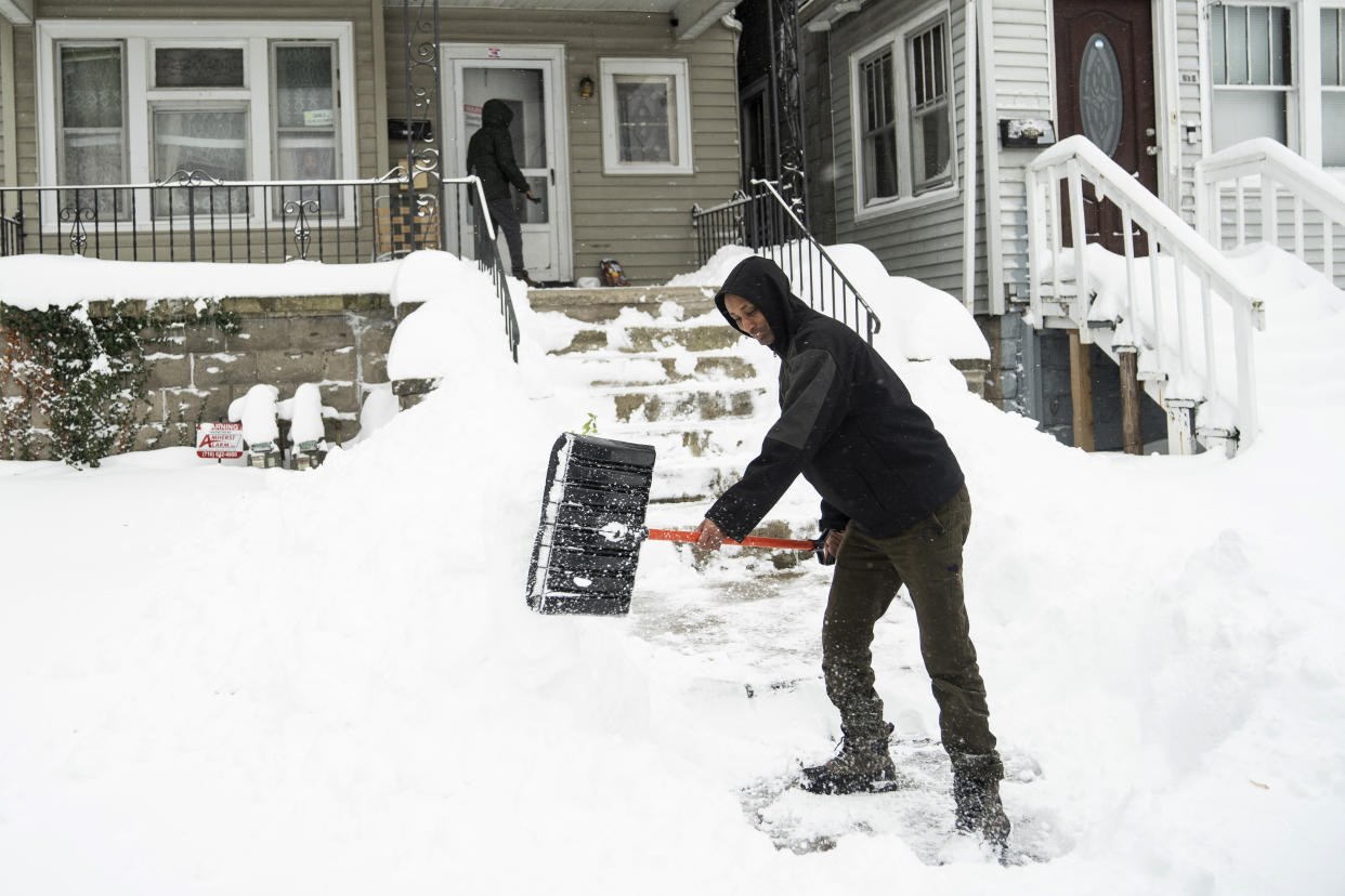 Ahmed Osman shovels his walk on the West Side, Saturday, Nov. 19, 2022 in Buffalo, N.Y. Residents of northern New York state are digging out from a dangerous lake-effect snowstorm that had dropped nearly 6 feet of snow in some areas and caused three deaths. The Buffalo metro area was hit hard, with some areas south of the city receiving more than 5 feet by early Saturday. (Libby March /The Buffalo News via AP)