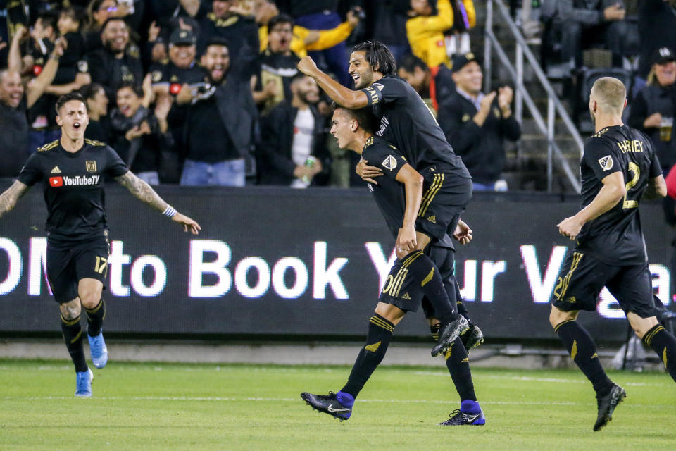 Los Angeles FC midfielder Eduard Atuesta, second from left, celebrates his goal with forward Carlos Vela, second from right, during the first half of the team's MLS soccer Western Conference final against the Seattle Sounders, Tuesday, Oct. 29, 2019, in Los Angeles. (AP Photo/Ringo H.W. Chiu)